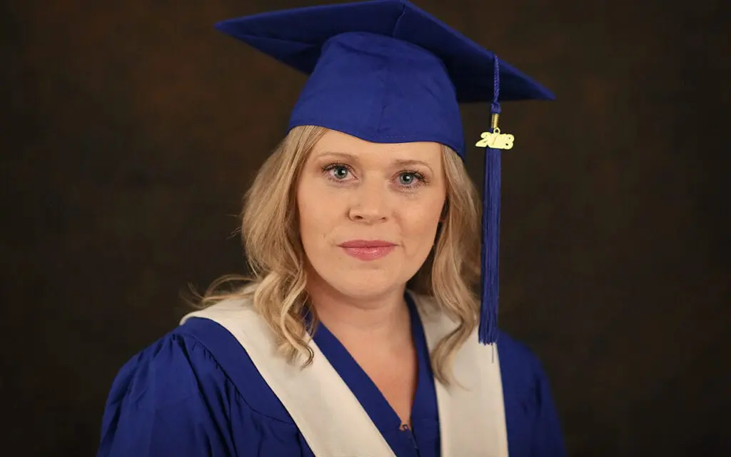 Krista May smiles in grad gown, proud of her accomplishments as a Cardiology Technologist.