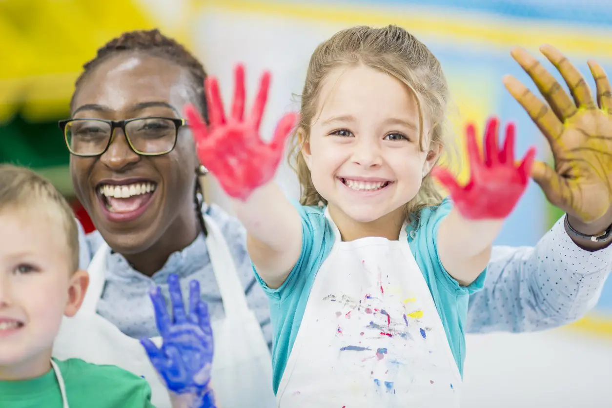 Early Childhood Educator with kids with painted hands