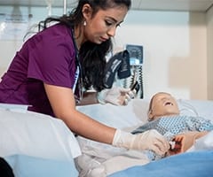 Nelofar on the Nursing Simulation Lab practicing wound care on a High Fidelity Mannequin at Stenberg College.